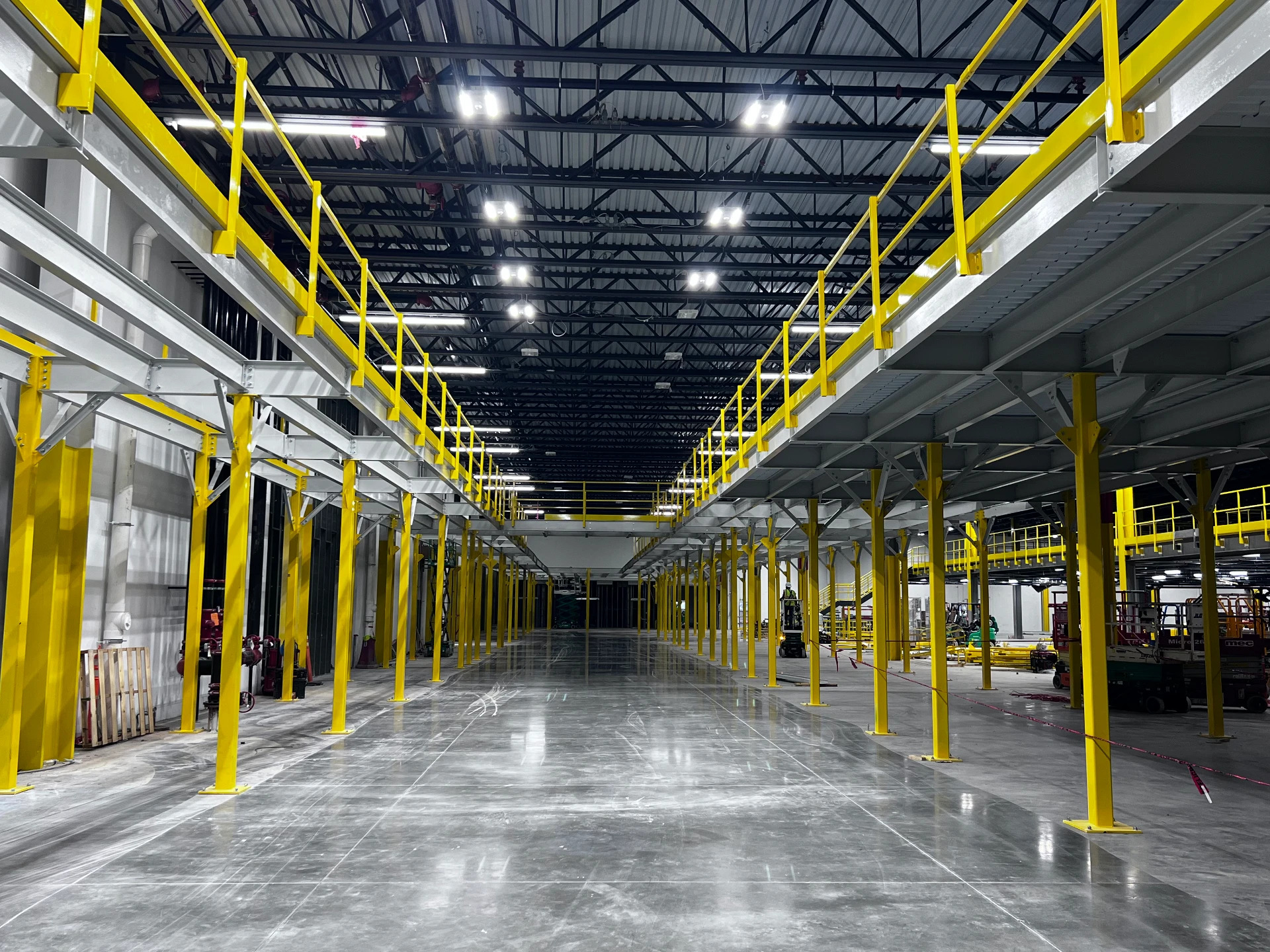 Steel mezzanine framing and decking being installed inside a warehouse
